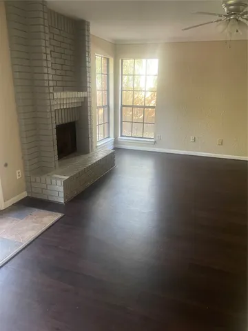 an empty room with windows and fireplace