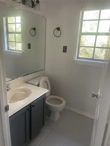 a bathroom with a sink a toilet and window