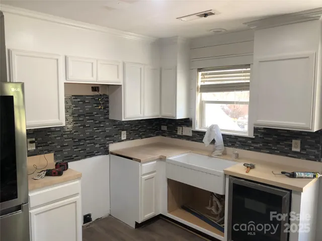 a kitchen with a sink stove top oven and cabinets
