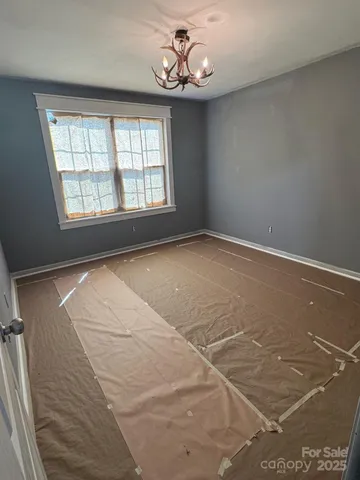 an empty room with windows and ceiling fan
