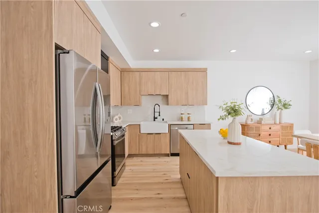 a kitchen with stainless steel appliances a refrigerator sink and stove