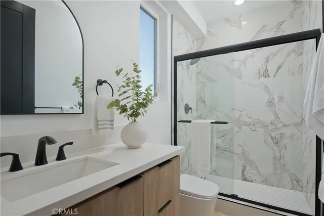 a bathroom with a granite countertop sink a mirror and shower