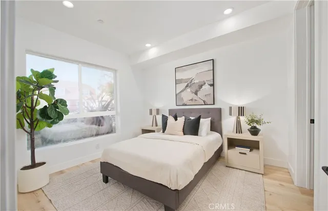 a bedroom with a large bed and a potted plant