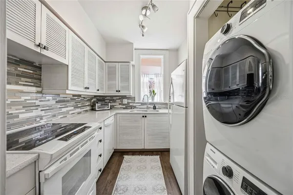 a kitchen with a sink and a washer dryer