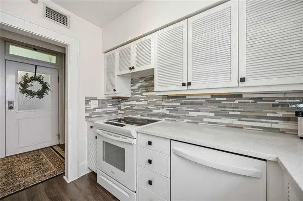 a kitchen with stainless steel appliances white cabinets and a window