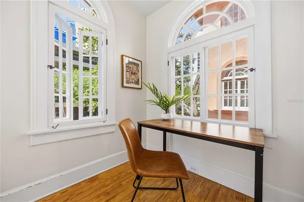 a view of a dining room with furniture a potted plant and wooden floor