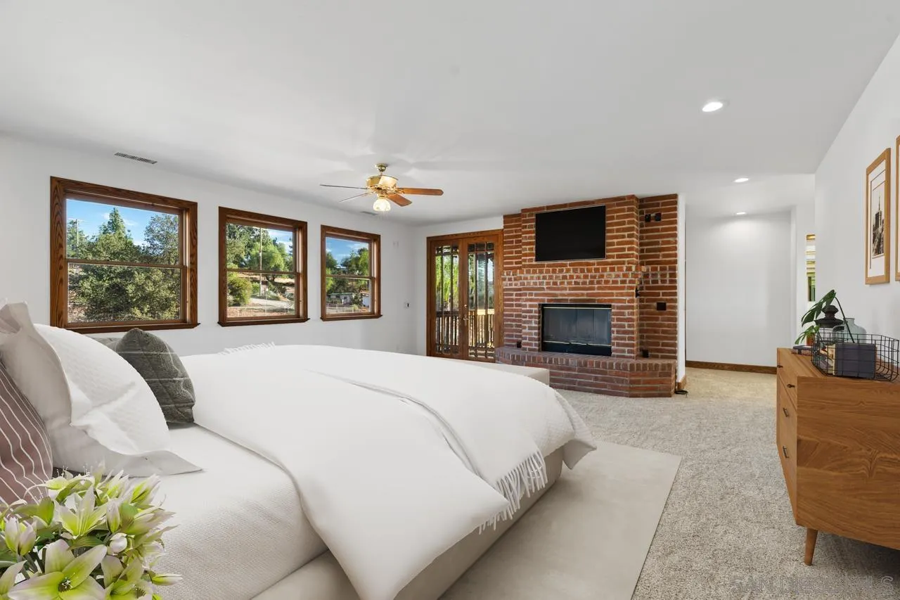 15718 Fruitvale Road Valley Center, CA 92082 - Photo 35 of 49 a bedroom with a balcony a bed and a fireplace