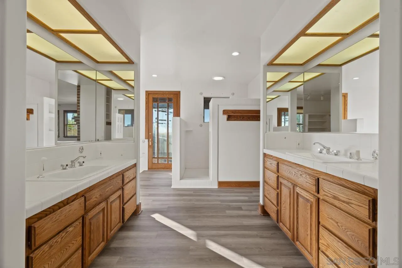 15718 Fruitvale Road Valley Center, CA 92082 - Photo 38 of 49 a spacious bathroom with a double vanity sink and a mirror