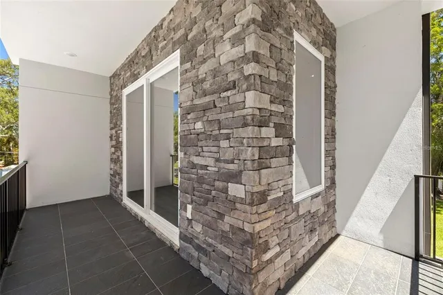 an empty room with wooden floor cabinet and windows