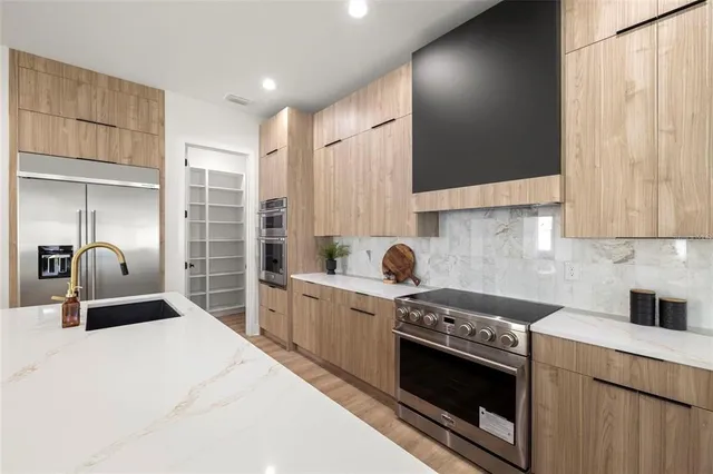 a kitchen with stainless steel appliances granite countertop a stove a sink and a refrigerator