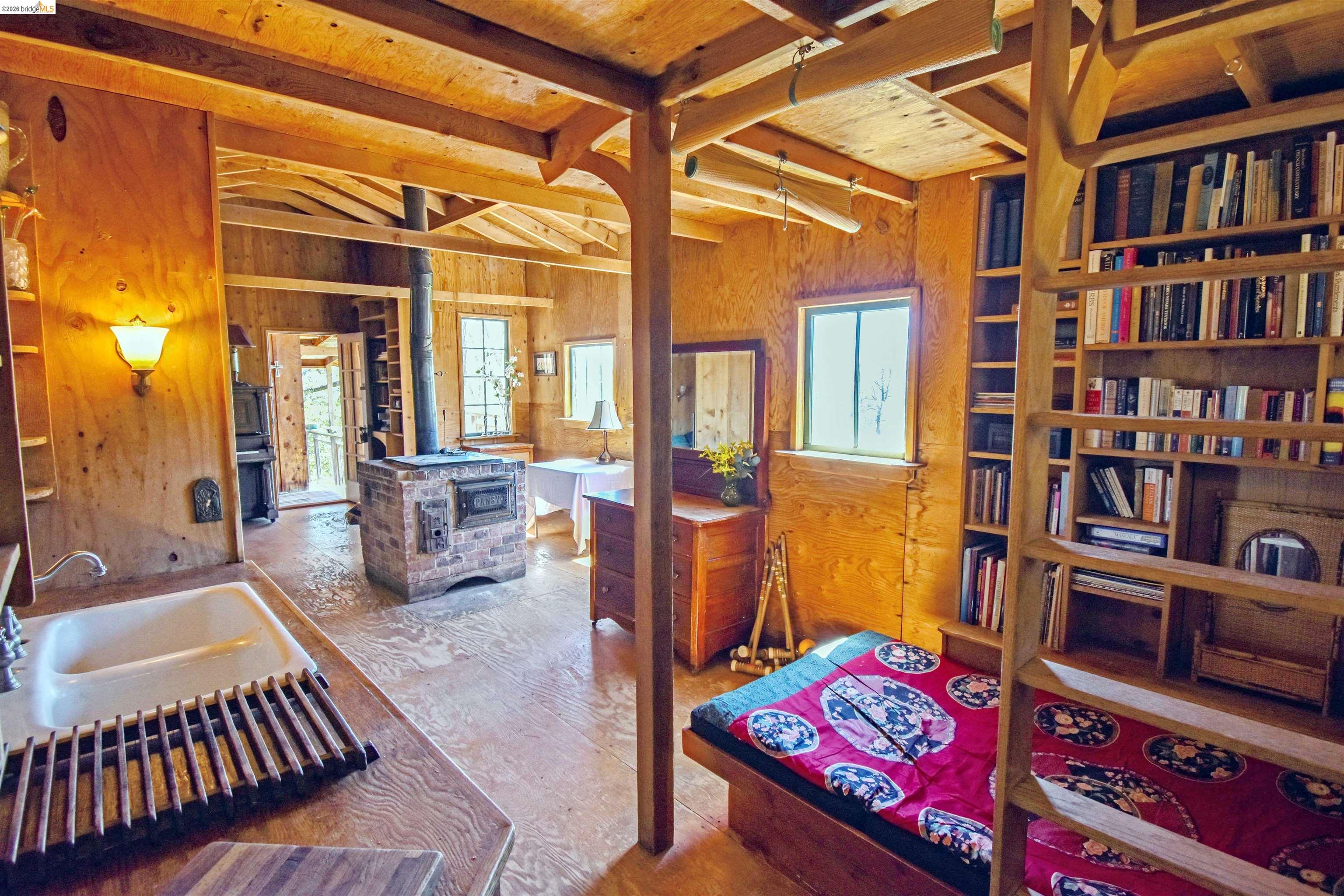 17270 Robin Ridge Road Sonora, CA 95370 - Photo 13 of 60 Bedroom with a wood stove and wooden walls