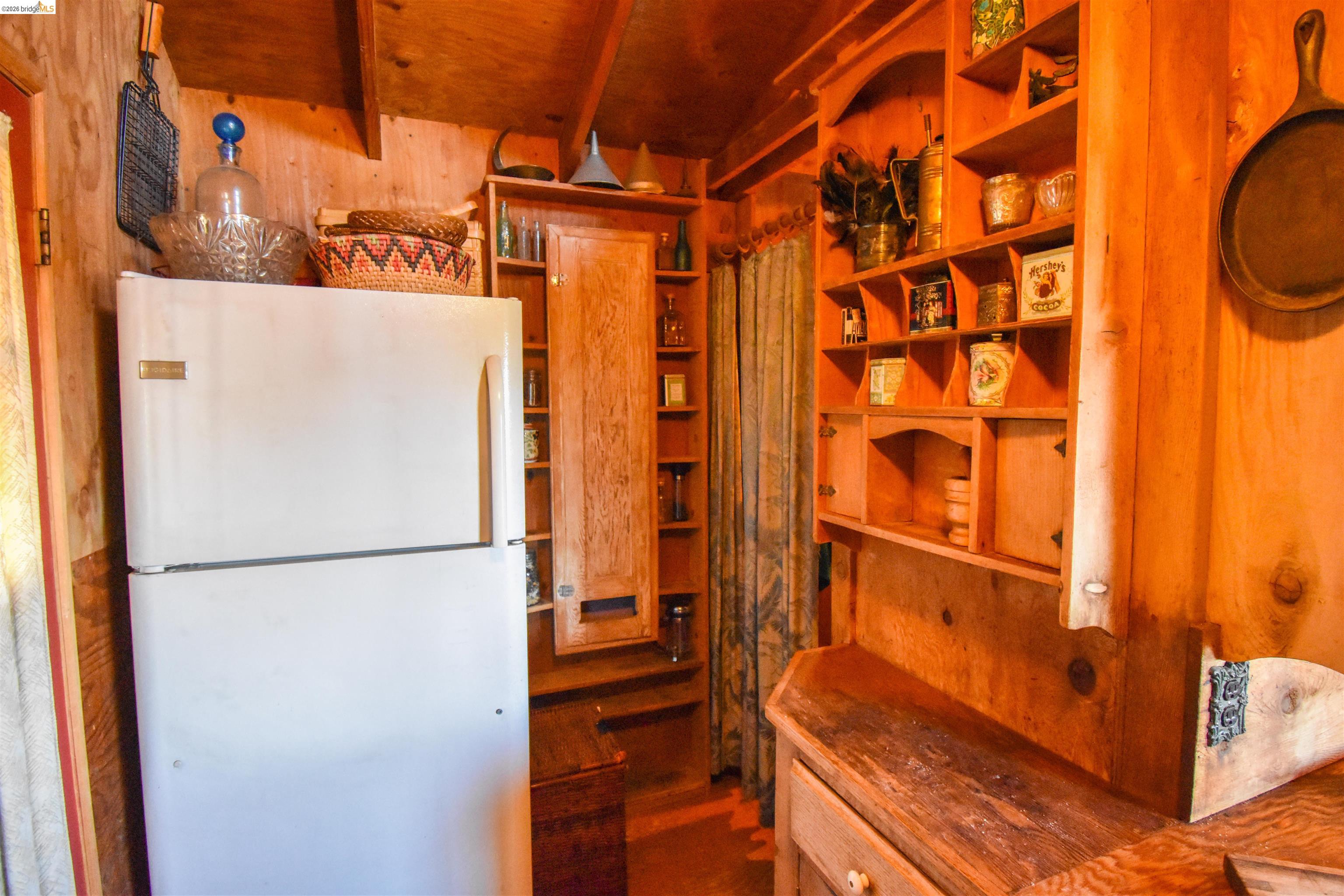 17270 Robin Ridge Road Sonora, CA 95370 - Photo 14 of 60 Kitchen with freestanding refrigerator, wood walls, and beamed ceiling