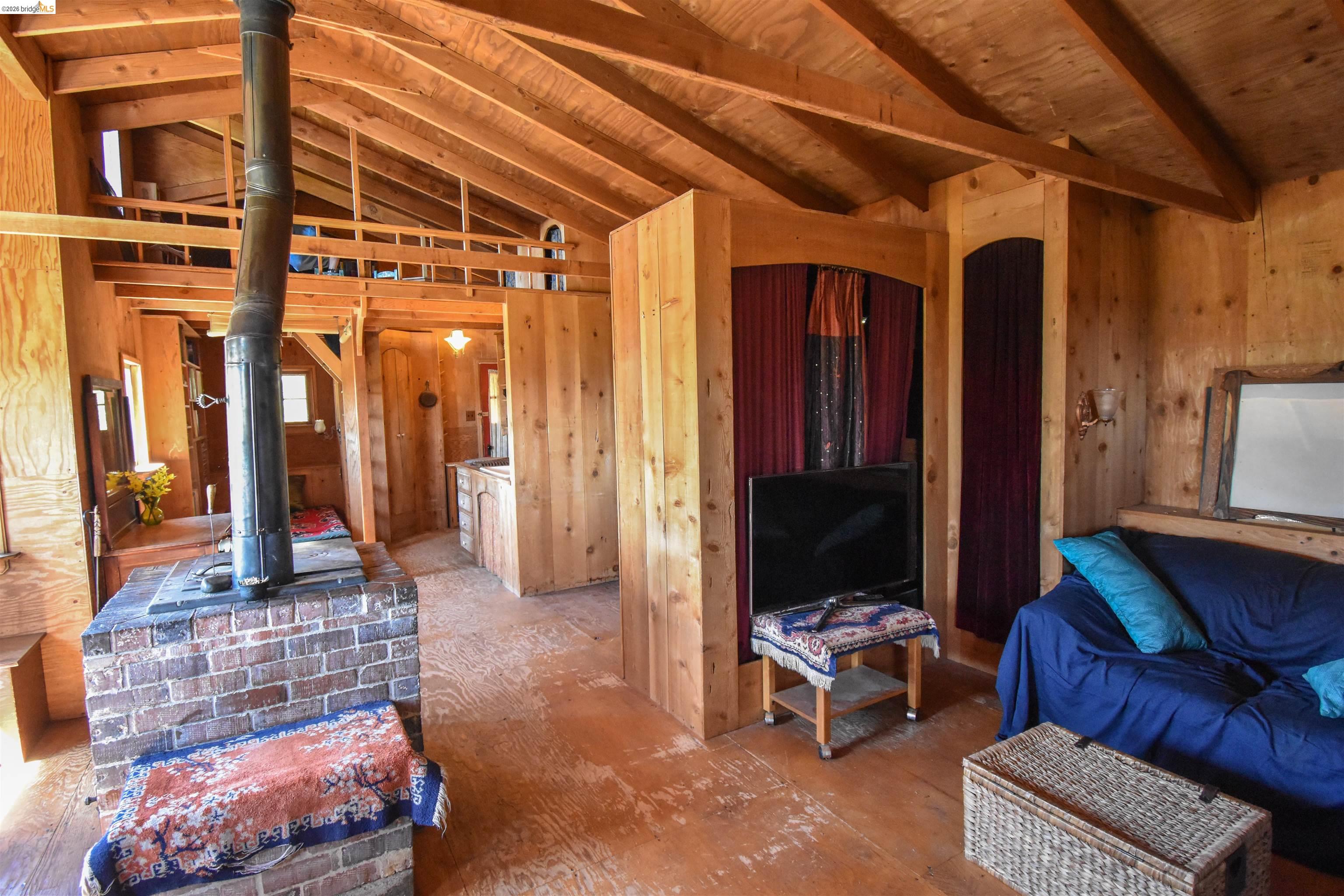 17270 Robin Ridge Road Sonora, CA 95370 - Photo 17 of 60 Living area with a wood stove and vaulted ceiling with beams
