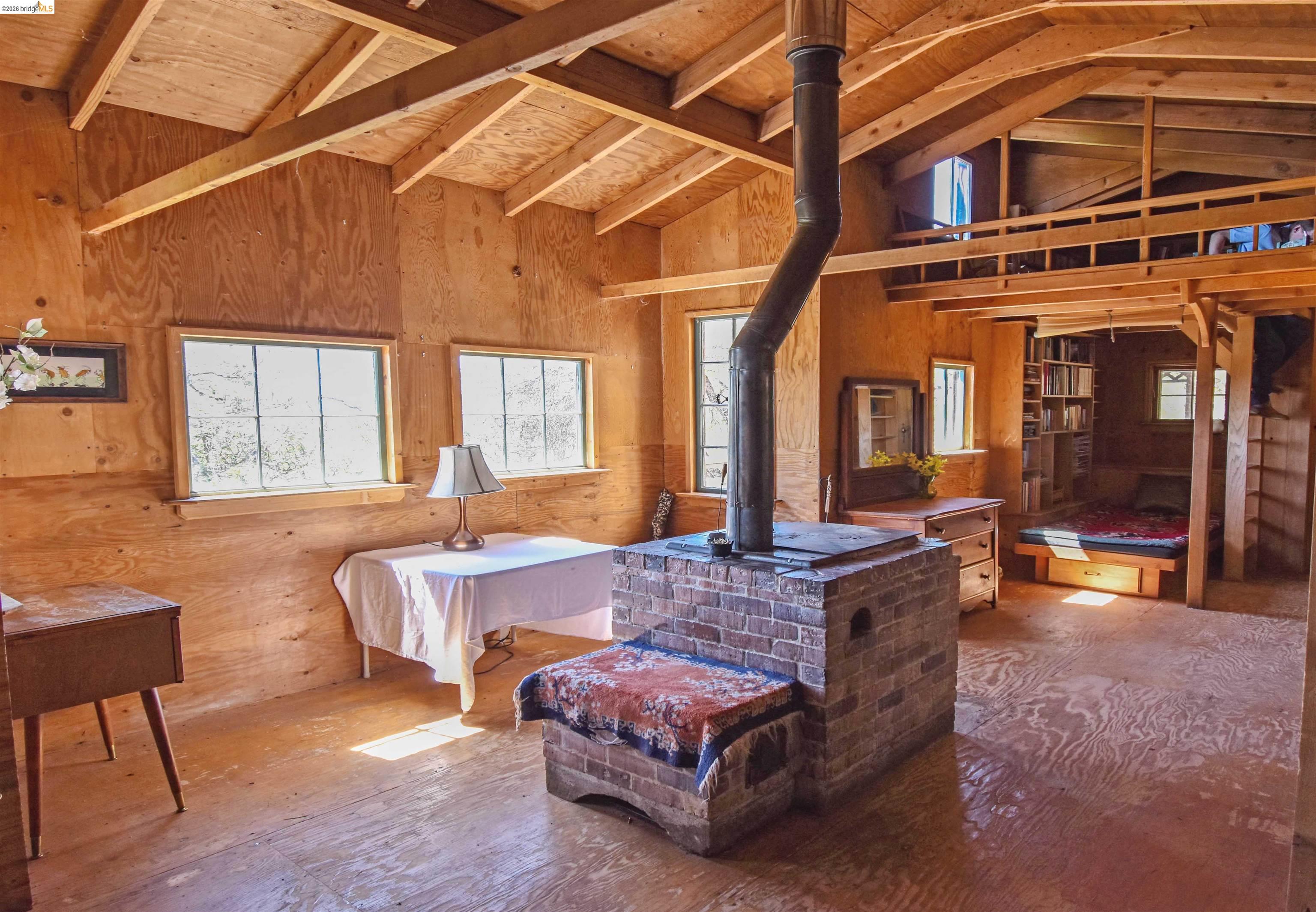 17270 Robin Ridge Road Sonora, CA 95370 - Photo 18 of 60 Bedroom featuring a wood stove and wood walls