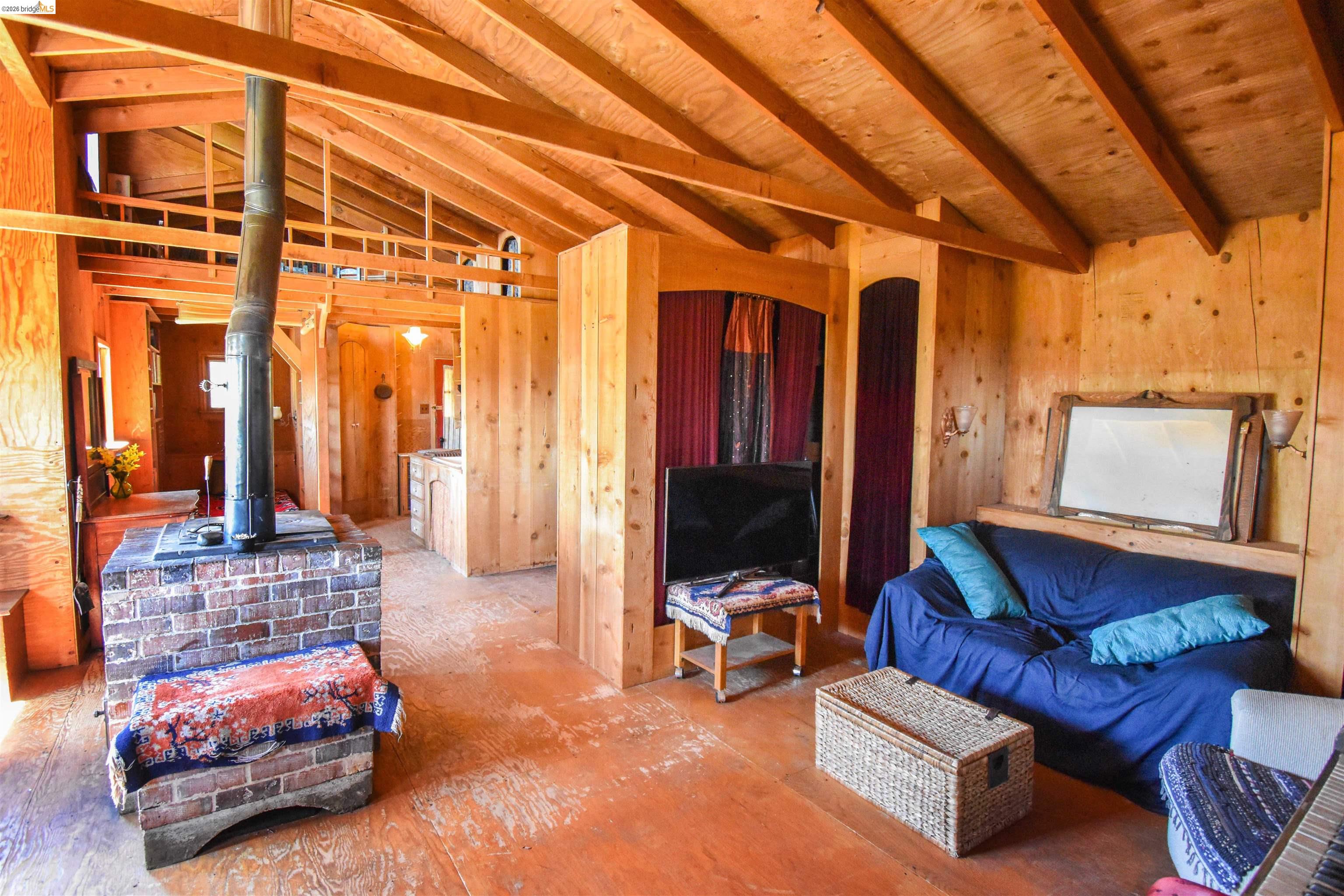 17270 Robin Ridge Road Sonora, CA 95370 - Photo 19 of 60 Living area featuring a wood stove and lofted ceiling with beams
