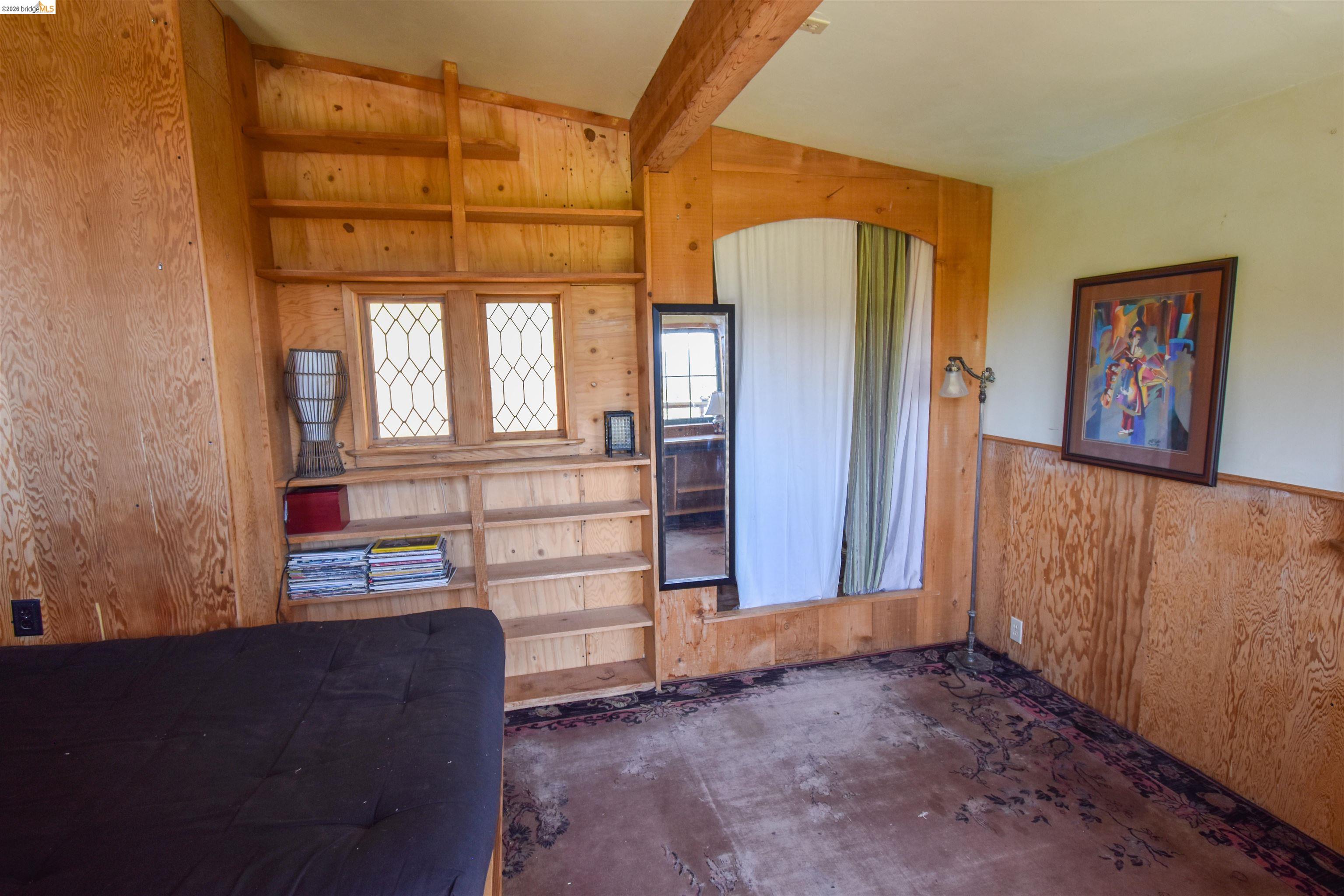 17270 Robin Ridge Road Sonora, CA 95370 - Photo 20 of 60 Bedroom with wooden walls, lofted ceiling with beams, and unfinished concrete flooring