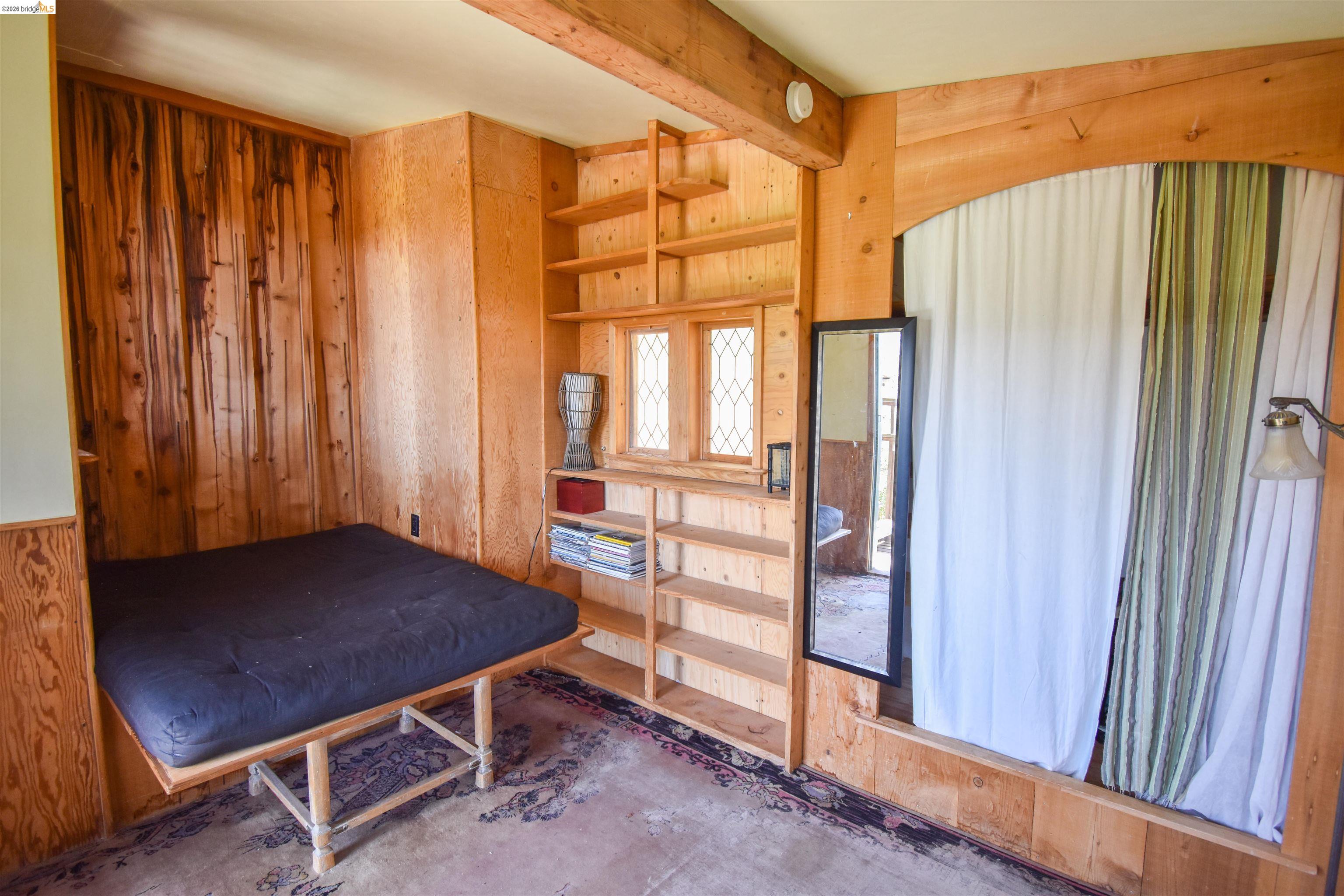 17270 Robin Ridge Road Sonora, CA 95370 - Photo 21 of 60 Bedroom featuring wooden walls and unfinished concrete floors
