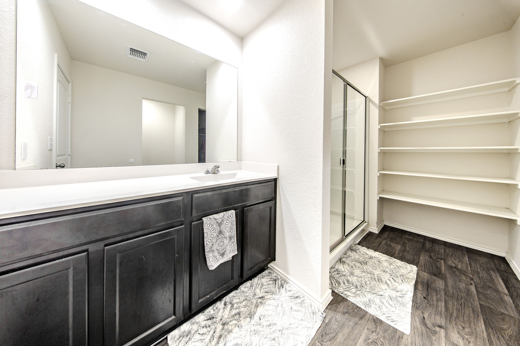 14903 Tuff Road Manor, TX 78653 - Photo 10 of 25 Ample built-in shelving and a sleek glass-enclosed shower highlight this organized bathroom space.