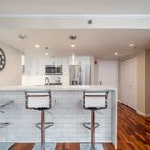 a living room with stainless steel appliances kitchen island granite countertop furniture and a view of kitchen