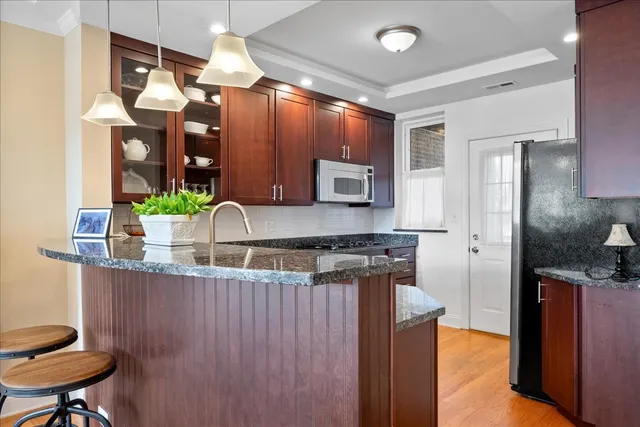 a kitchen with stainless steel appliances granite countertop a sink stove and refrigerator