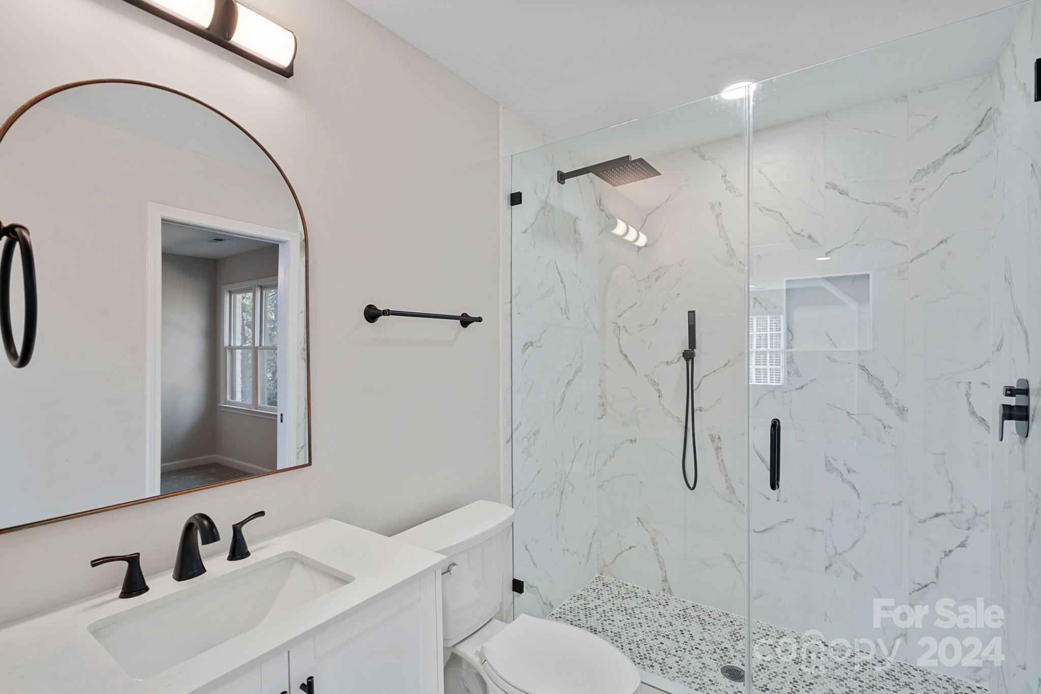 21140 Bethel Church Road Cornelius, NC 28031 - Photo 30 of 48 a bathroom with a toilet sink a mirror and shower