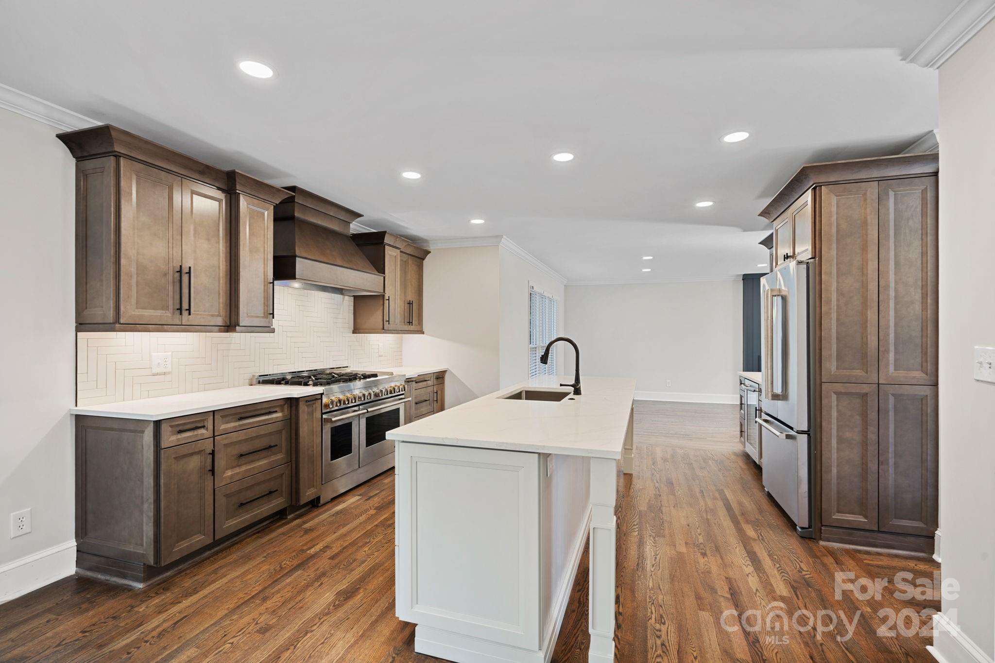 21140 Bethel Church Road Cornelius, NC 28031 - Photo 10 of 48 a large kitchen with stainless steel appliances granite countertop a lot of counter space and wooden floors