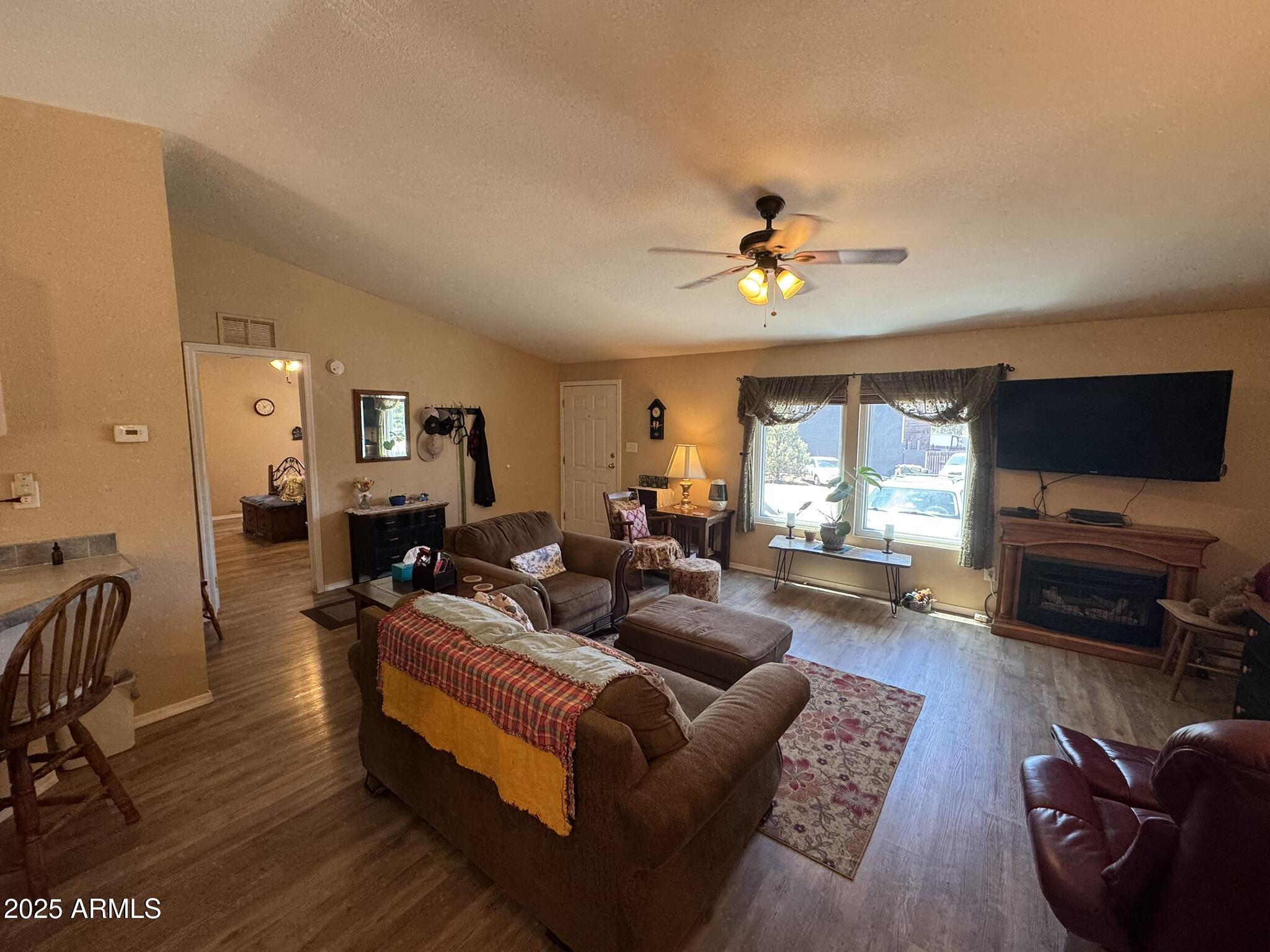 1998 Stagg Run Overgaard, AZ 85933 - Photo 18 of 61 a living room with furniture ceiling fan and a flat screen tv