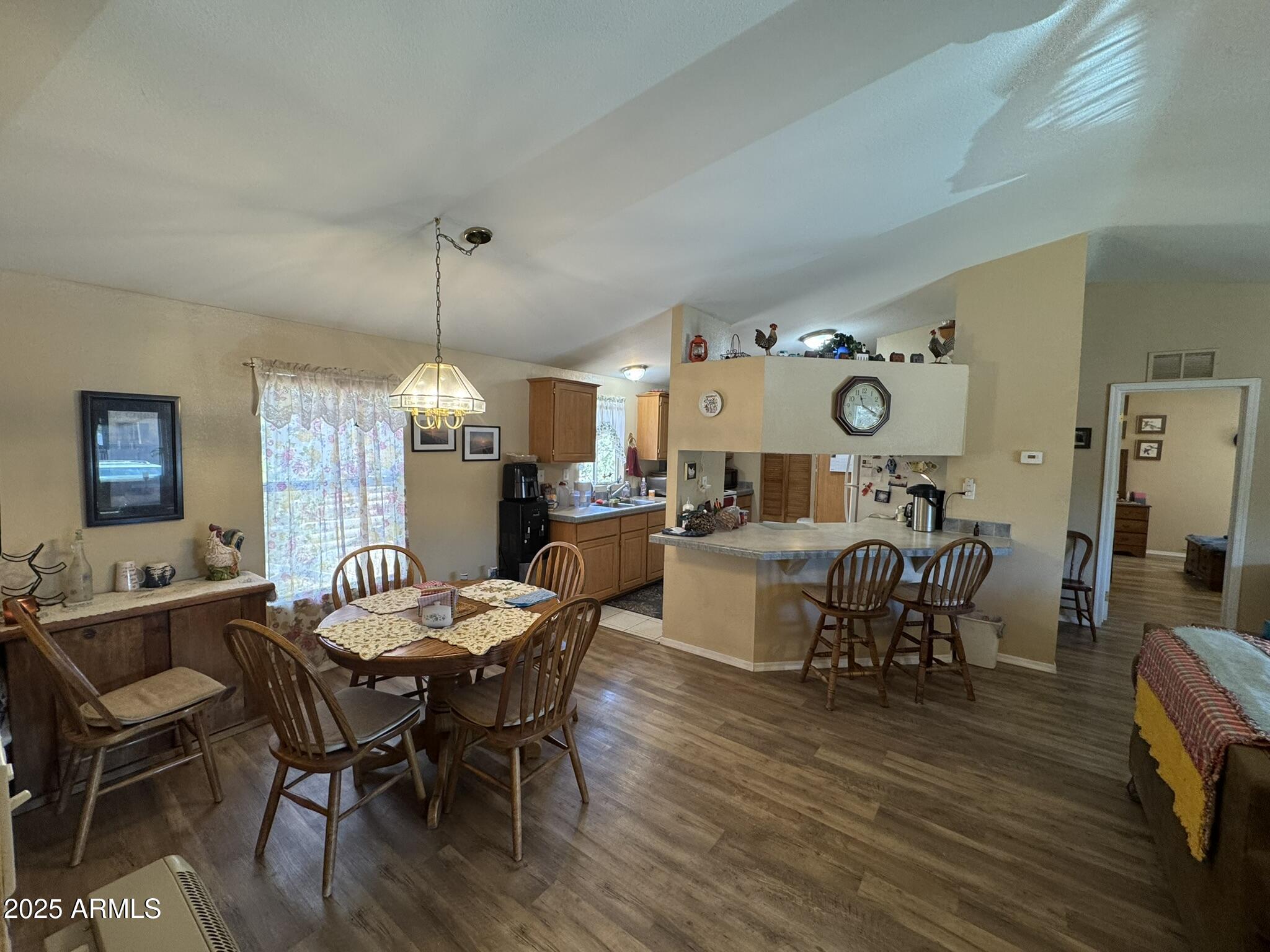 1998 Stagg Run Overgaard, AZ 85933 - Photo 50 of 61 a dining room with wooden floor a chandelier a wooden table and chairs