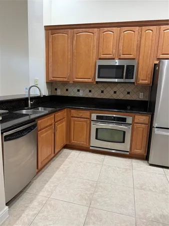 a kitchen with granite countertop a stove top oven microwave and sink