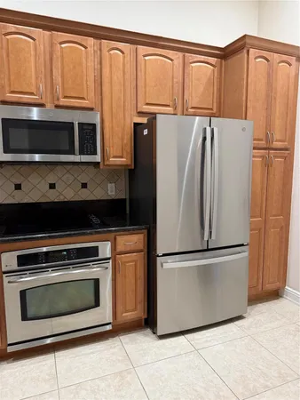 a kitchen with stainless steel appliances granite countertop a refrigerator stove and microwave