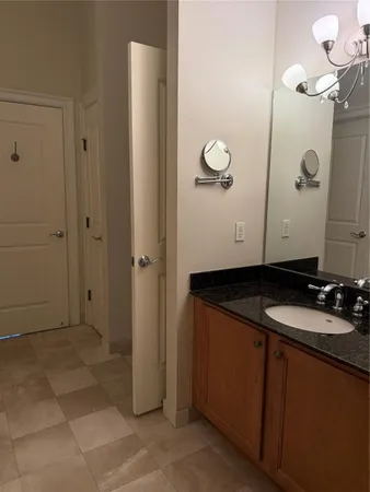 a bathroom with a granite countertop sink a mirror and shower