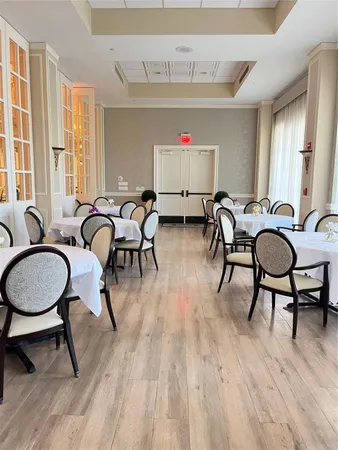 a room with furniture pool table gym equipment wooden floor and windows