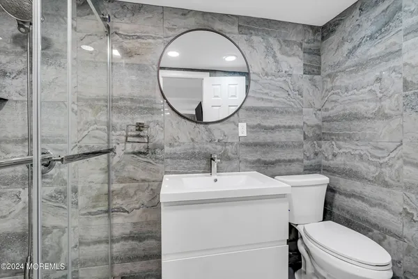 a bathroom with a toilet a sink and a mirror