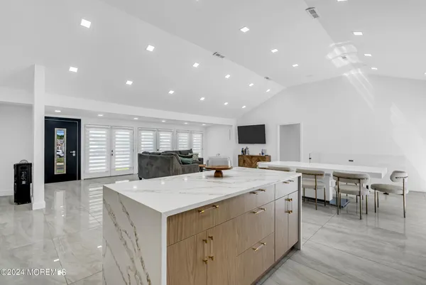 a kitchen with a stove a sink a kitchen island with chairs and wooden floor