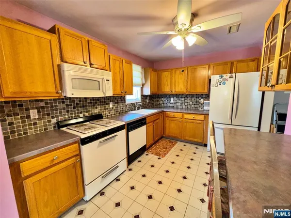 a bathroom with a sink a refrigerator and a window