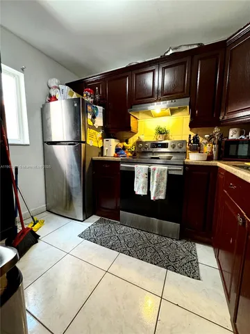 a kitchen with stainless steel appliances granite countertop a refrigerator a stove a sink and dishwasher