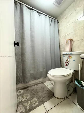 a white toilet sitting next to a shower curtain