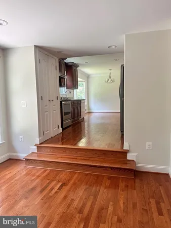 a view of a room with wooden floor and kitchen
