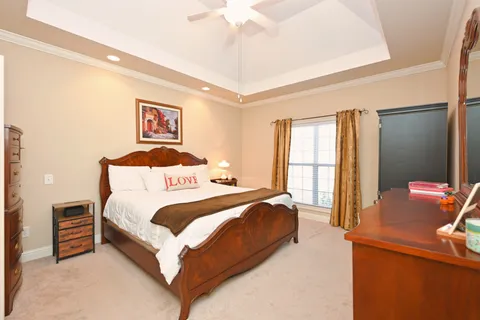 a bedroom with a bed and a dresser next to a window