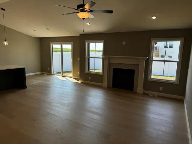 an empty room with windows and fireplace