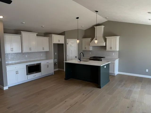 a kitchen with stainless steel appliances granite countertop a stove a sink and a refrigerator