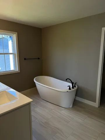 a bathroom with a bathtub and window