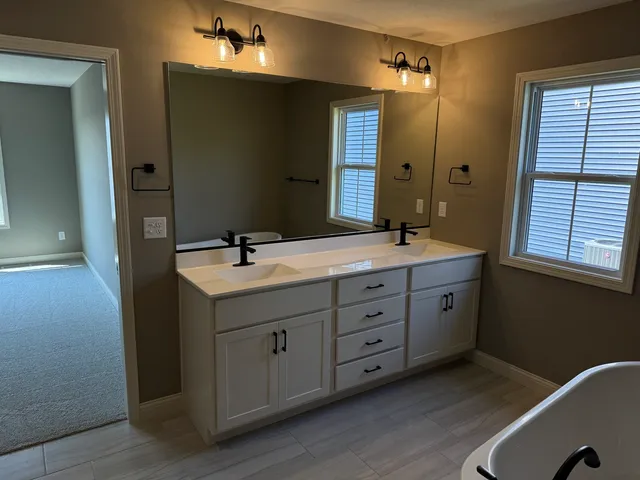 a bathroom with a double vanity sink a mirror and a shower