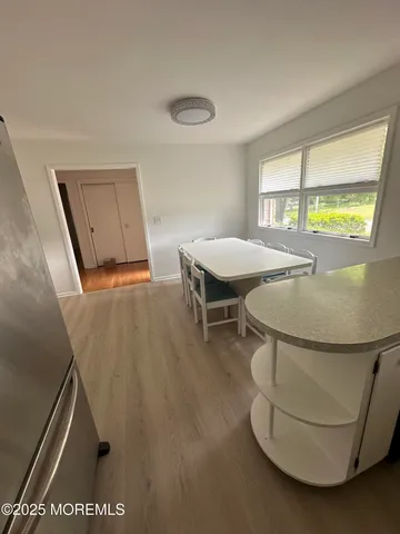 a kitchen with a dining table chairs and refrigerator