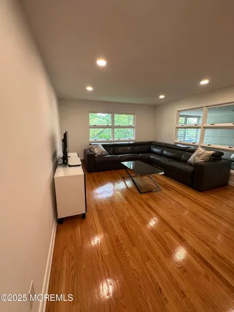 a living room with furniture and a wooden floor