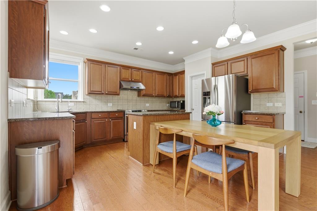 2572 Larson Creek Way Northwest Duluth, GA 30097 - Photo 22 of 50 a kitchen with a table chairs refrigerator and microwave