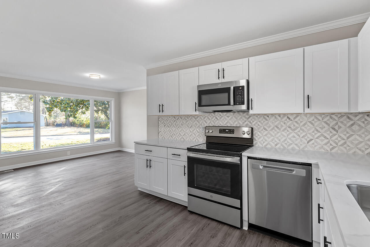 706 Friar Tuck Road Raleigh, NC 27610 - Photo 10 of 38 a kitchen with granite countertop white cabinets and appliances