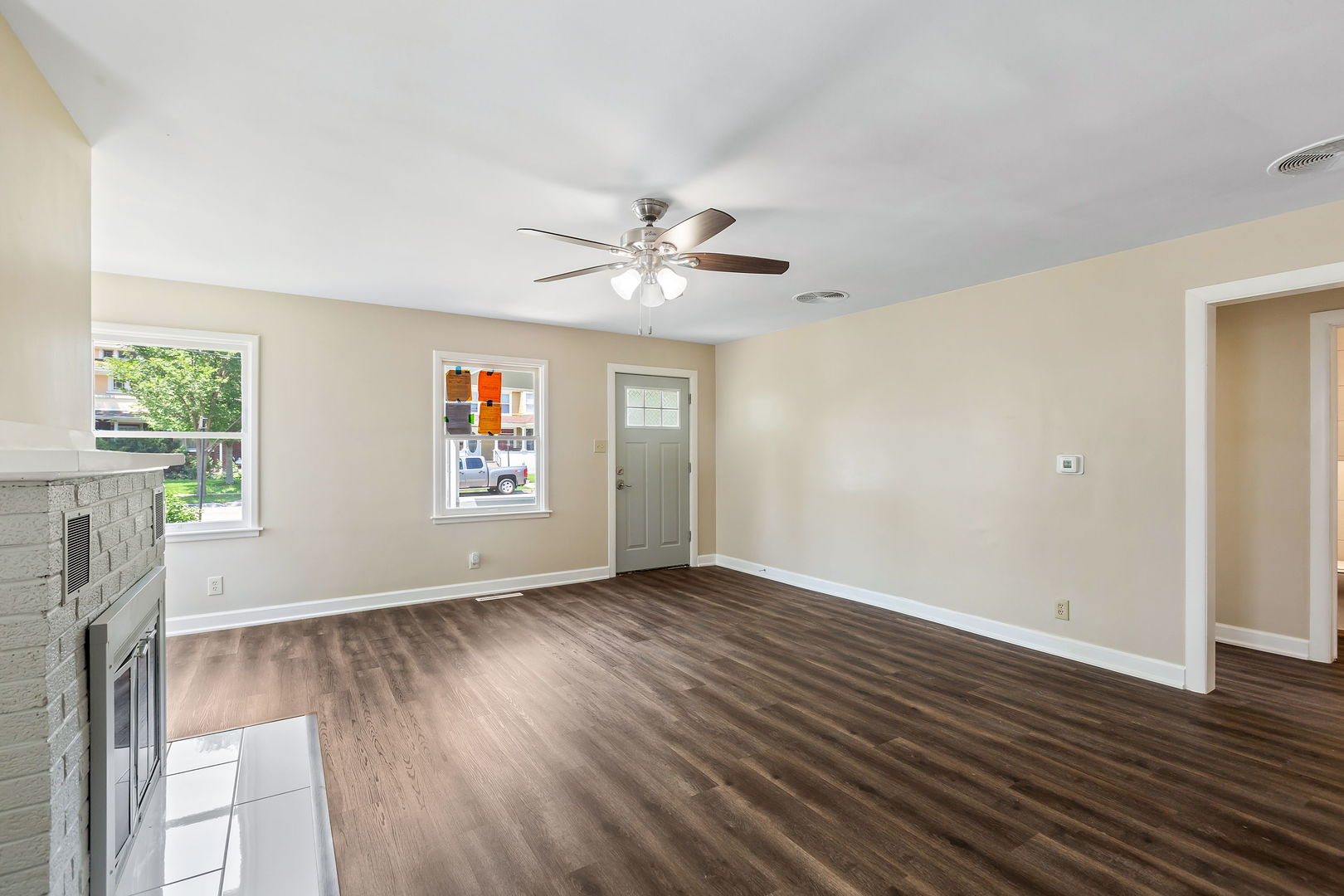 467 North Spring Street Elgin, IL 60120 - Photo 4 of 18 an empty room with wooden floor chandelier fan and windows