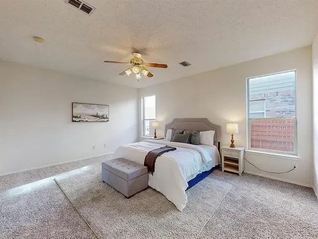 a spacious bedroom with a bed and a window