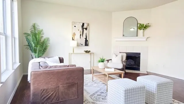 a living room with furniture a fireplace and a potted plant